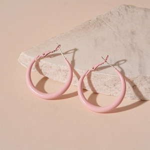 Detailed view of pink pastel hoop earrings on natural stone with soft shadow detail