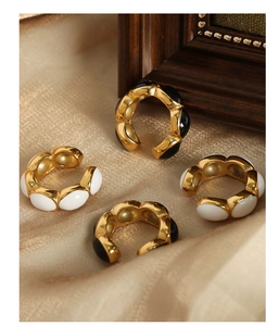 Detail of vintage gold plated earrings with black and white enamel on silk fabric