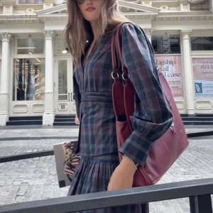 Completo con abito a quadri retrò e borsa in pelle rosso vino per uno stile street