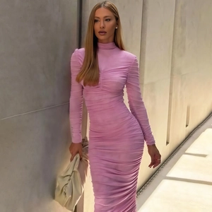 Détail de la texture froncée élégante et de la coupe ajustée de cette robe rose à manches