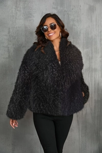 Detail of a chic black faux fox fur jacket showing plush texture and short fashion cut