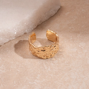 Detailed close-up of golden adjustable ring featuring a unique hammered metal texture finish