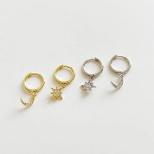 Detail of S925 sterling silver star and moon earrings with cubic zirconia in gold and silver