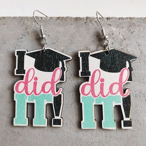 Detail of wooden graduation earrings featuring a black cap and I did it text