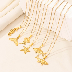 Detail of 18K gold plated stainless steel ocean theme pendants featuring marine textures