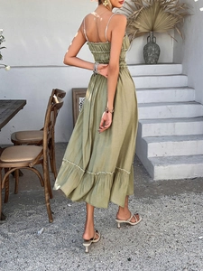 Back view of a long sage green A-line dress with ruffled layers and a flowy silhouette