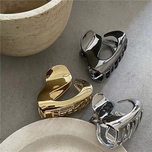 Detail of irregular liquid metal hair claws in gold, silver and gunmetal grey finishes