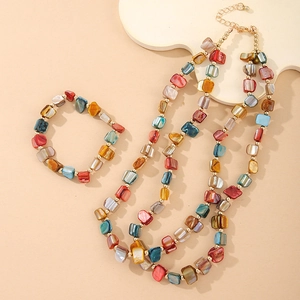 Detail of colorful irregular shell beads and gold spacers on bohemian necklace set
