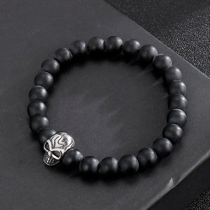 Detailed shot of black matte beaded bracelet featuring a silver skull charm accessory