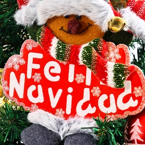 Close-up of a festive plush pendant with bells and Feliz Navidad sign on a Christmas tree