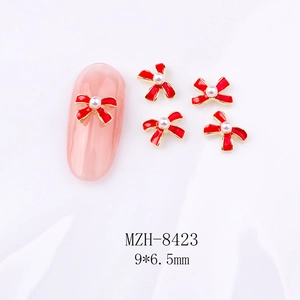 Detail von 9x6,5mm rotem Schleifen-Nagelcharm mit weißer Perle auf rosa Nageltipp
