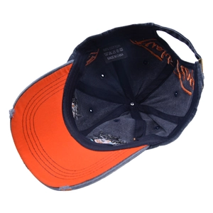 Navy cotton baseball cap with orange brim and embroidered interior details and worn edges