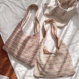 Close-up of crochet knit hobo bags with colorful dots and wide fabric shoulder straps