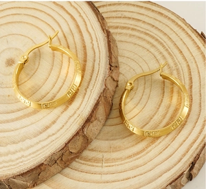 Detail of 18K gold stainless steel hoop earrings with engraved Greek key pattern
