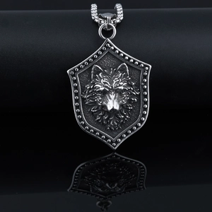 Close-up of gothic shield necklace with detailed wolf head relief and bead chain