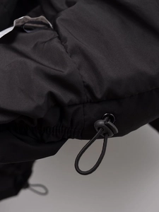 Detailaufnahme des verstellbaren Kordelzugs und winddichten Stoffs an schwarzer Jacke
