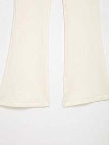 Détail du bas de pantalon évasé blanc crème montrant la texture du tricot haute densité