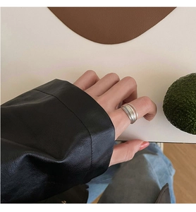 Close-up of layered silver geometric ring worn with a black leather jacket for women