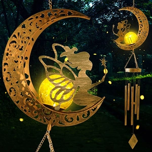 Solar wind chime with bronze moon, glowing glass ball, and elf silhouette in the garden