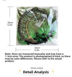 Detailed view of handmade black dream catcher with green feathers and 16cm size measurement