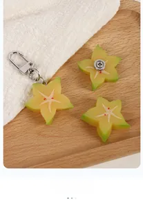 Detailed view of realistic PVC starfruit slices with metal lobster clasp on wood tray