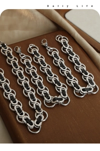 Detailed view of punk geometric silver and black titanium steel chain necklaces on a tray