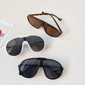 Flat lay of oversized vintage kids sports sunglasses in tortoiseshell, white and black