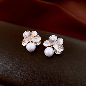 Macro view of 18K gold plated flower earrings with glossy enamel petals and white pearls
