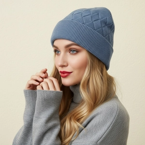 Detail of blue knitted beanie showing thick core-spun yarn texture and ribbed cuff design