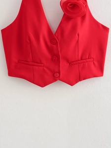 Detail view of red V-neck vest with 3D floral decoration and button front closure