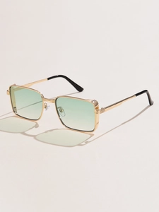 Detail view of gold metal sunglasses with light green lenses and textured temple arms
