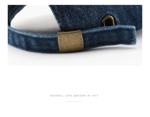 Detail of vintage navy denim baseball cap featuring an adjustable antique brass buckle