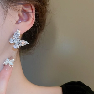 Detail of silver butterfly earrings and ring with marquise opal and zircon inlay