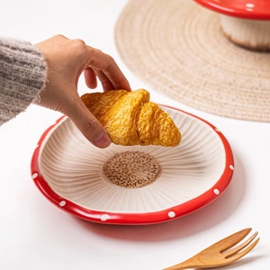 Close-up of red mushroom-style ceramic plate with white polka dots for home dining