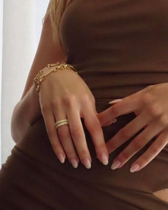 Detail showing 18k gold link chain bracelet paired with micro-paved zircon stackable rings