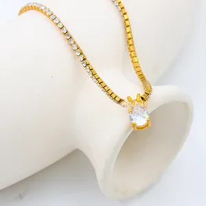 Detail shot of a gold birthstone necklace with a round zircon pendant on white ceramic