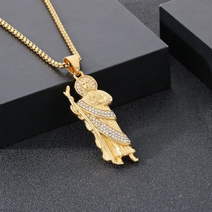 Gros plan détaillé du pendentif Saint Jude en or avec strass et chaîne de type boîte