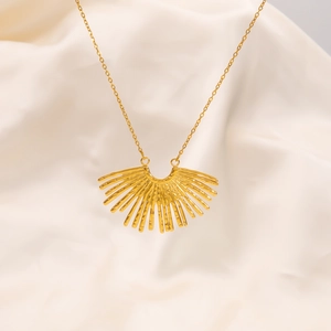 Macro shot of 18k gold radial fan-shaped pendant on minimalist thin link chain