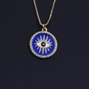 Detail of gold-plated evil eye pendant with blue enamel and sparkling crystal pavé