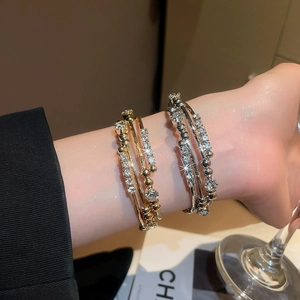 Detail of layered geometric bracelet with sparkling rhinestones on an elegant model