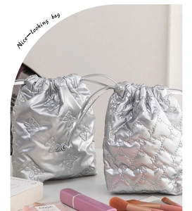 Detail of silver metallic drawstring pouch featuring bow design and heart quilting