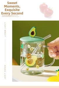 Close-up of glass cup set with cute avocado lid decoration and transparent straw