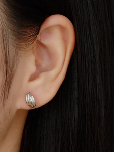 Close-up of minimalist S925 silver stud earring featuring a twisted spiral knot design