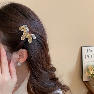 Close-up of a sparkling crystal pony hair clip worn on a woman's brown wavy hair