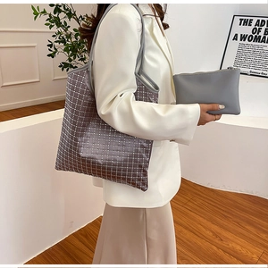 Detail of large purple rhinestone tote bag and matching grey clutch set for women