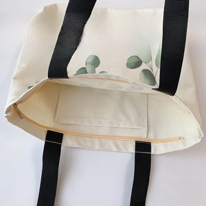 Detail of the canvas tote bag featuring a secure zipper closure and internal wall pocket