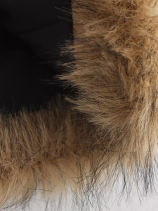 Close-up van de zachte imitatiebontkraag op het herfstvest toont textuur en dichtheid