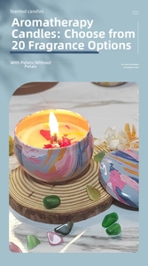 Scented candle in artistic tin with dried rose petals on a wooden tray with decor