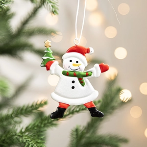 Festive snowman Christmas tree ornament with red scarf and green hat on a tree branch