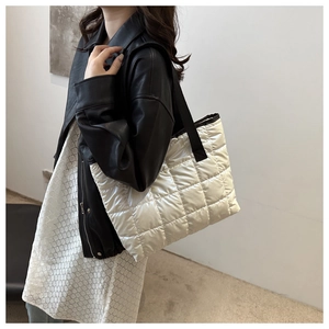 Close-up of silver quilted space cotton tote bag with crossbody strap on model